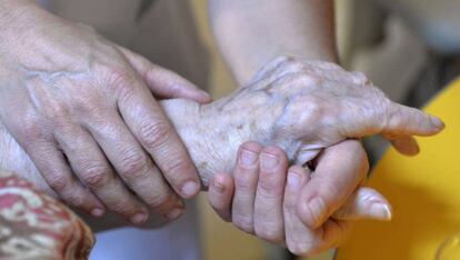 Una persona atiende a una anciana.