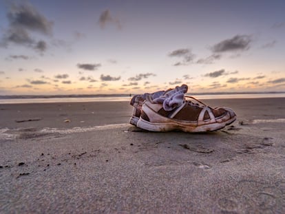 Un par de zapatillas olvidadas en una playa.