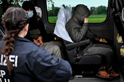 Detained migrants sit in a police van near Frost, Germany, 11 October 2023.