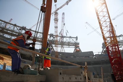 Dos obreros trabajan en la construcción en el Estadio Icónico de Lusail en Doha, en diciembre de 2019.
