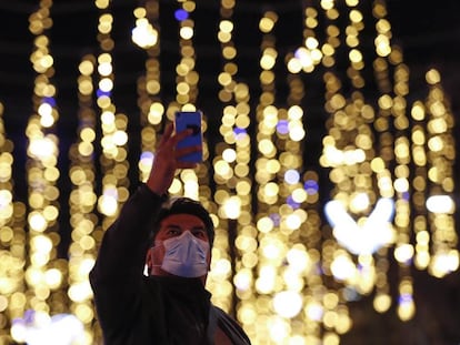 Un home fa una foto de l'enllumenat nadalenc al centre de Barcelona.
