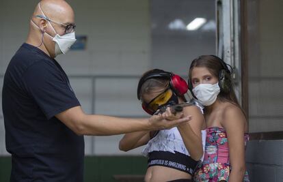 Un instructor entrena a dos niñas de 10 años sobre cómo disparar correctamente un arma de fuego en un campo de tiro en São Paulo, Brasil, el pasado 6 de marzo.