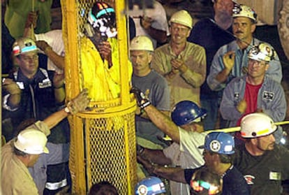 El último  de los mineros es rescatado mientras sus compañeros aplauden.