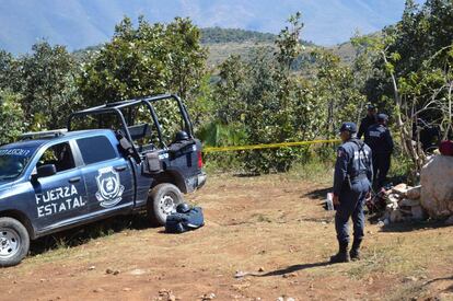 Policías resguardan el sitio donde hallaron 20 fosas clandestinas, en Zitlala