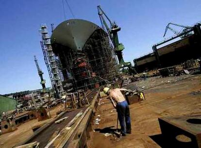 Un trabajador barre en el astillero de Gdansk, cerca de uno de los últimos barcos construidos en las instalaciones, en 2005.