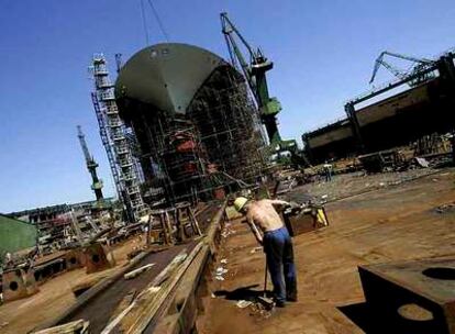 Un trabajador barre en el astillero de Gdansk, cerca de uno de los últimos barcos construidos en las instalaciones, en 2005.