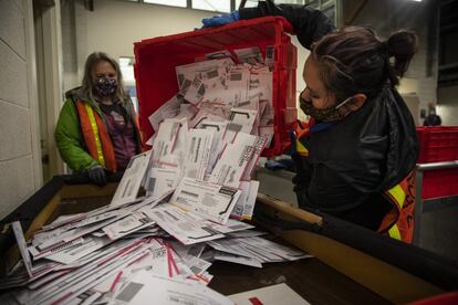 Trabajoras electorales vacían las papeletas de una urna en la División de Elecciones del Condado de Multnomah, en Portland, Oregon.