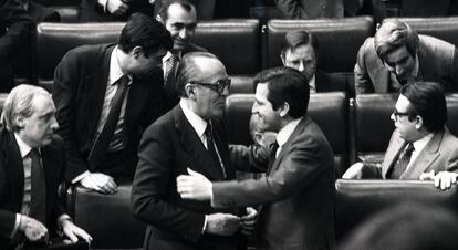 Adolfo Suárez (d), presidente saliente del Gobierno, abraza a Leopoldo Calvo Sotelo, tras su investidura como nuevo presidente, en el Congreso de los Diputados el 25 de febrero de 1981, tras la intentona del golpe de Estado del 23-F.