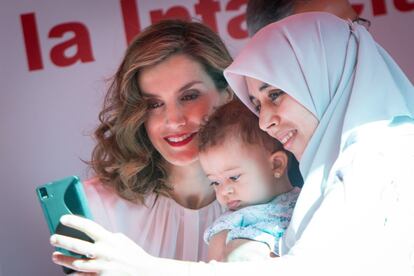 Doña Letizia se hace una foto con una mujer y su hijo.