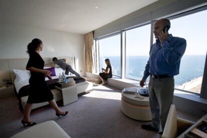 Personal del hotel W de Barcelona prepara los detalles de una suite. Abajo, una empleada enfría una botella de champán.