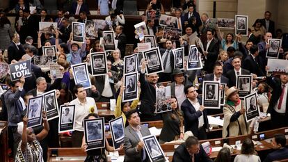 Senadores y representantes a la Cámara sostienen fotos de víctimas del conflicto armado, durante la instalación del nuevo Congreso Nacional, en Bogotá.