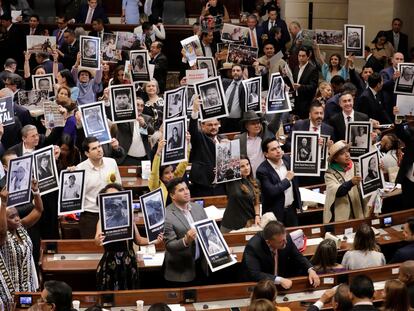 Senadores y representantes a la Cámara sostienen fotos de víctimas del conflicto armado, durante la instalación del nuevo Congreso Nacional, en Bogotá.