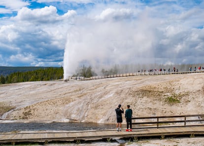 Visitantes observan el géiser Beehive en erupción en el Parque Nacional de Yellowstone, en Wyoming (Estados Unidos).