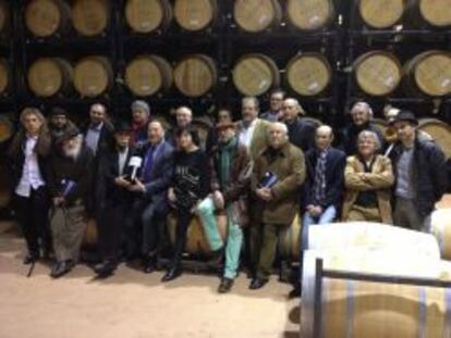 Los poetas y pintores que participan en la iniciativa solidaria de Emina posan junto a Carlos Moro, presidente de Matarromera (en el centro, con corbata), en las bodegas de la compa&ntilde;&iacute;a.