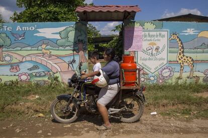 Maribel, con su hijo en su motocicleta durante su jornada de trabajo vendiendo gas.