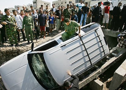 Un policía palestino entra en el coche de Tareq Abu Rayab tras el atentado de ayer en Gaza.