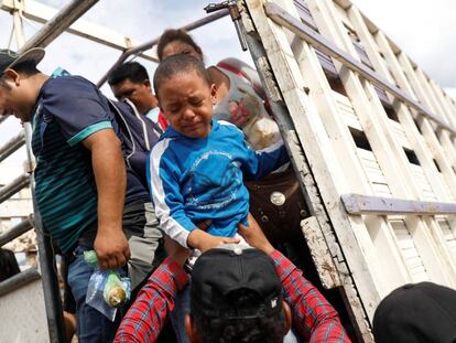 Un niño hondureño llora al bajar de un camión de la caravana. 