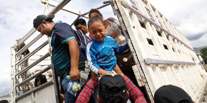 Un niño hondureño llora al bajar de un camión de la caravana. 
