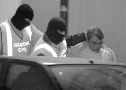 La Guardia Civil introduce en un coche a uno de los españoles detenidos en Valencia.