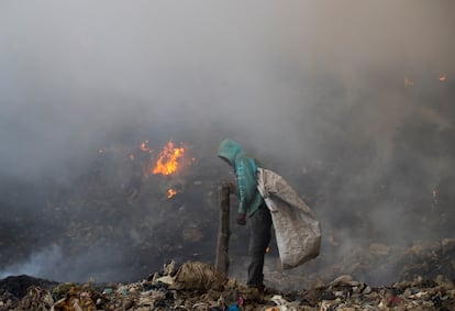 Un trabajador busca entre la basura para reciclar durante el gigantesco incendio en el vertedero de Duquesa, en abril de 2020.