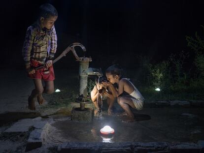 Niños beben agua en Pevre Badhai, India.