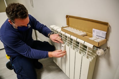 Un técnico instala un contador individual en un radiador de una vivienda en Madrid. 