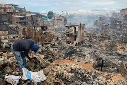 Un residente del vecindario de Educandos intenta recuperar algunas de sus pertenencias entre los escombros, un día después del masivo incendio, el 18 de diciembre.
