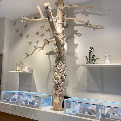 Decoración de un árbol con mariposas que se encuentra en las tiendas Apodemia.
