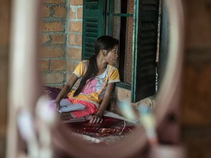 Una niña observa cómo su madre habla con una trabajadora social en Phon Chantorn, Camboya.
