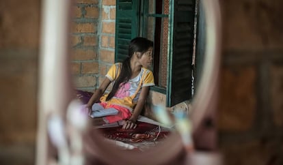 Una niña observa cómo su madre habla con una trabajadora social en Phon Chantorn, Camboya.