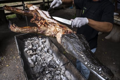 Un trabajador corta la carne de un cocodrilo asado para servir a los visitantes en Malai Farm, Phetchaburi. Tailandia se encuentra entre los principales productores de cocodrilos del mundo, con una estimación de 700.000 ejemplares criados en granjas, según el diario 'Bangkok Post'.