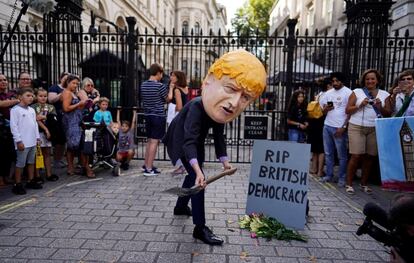 Un hombre disfrazado del primer ministro británico, Boris Johnson, sostiene una pala junto a una lápida ficticia en las afueras de Downing Street en Londres (Reino Unido). La reina Isabel II aprobó este miércoles la solicitud del Gobierno del Reino Unido de suspender el Parlamento, en medio de una creciente crisis por el Brexit.