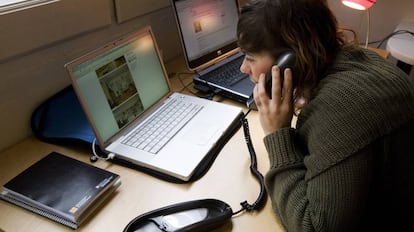 Una mujer habla desde el teléfono fijo en una foto de archivo.