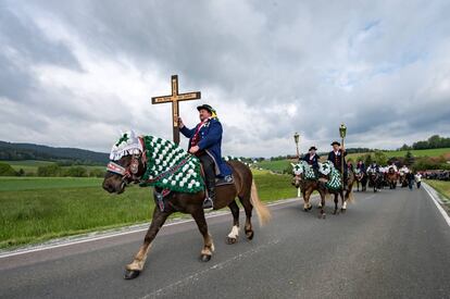 Varias personas montadas en caballos y vestidas con trajes tradicionales bávaros participan en la procesión del 'Lunes de Pentecostés' camino a la iglesia de San Nicolás en Steinbuehl, en Bad Koetzting, Alemania.