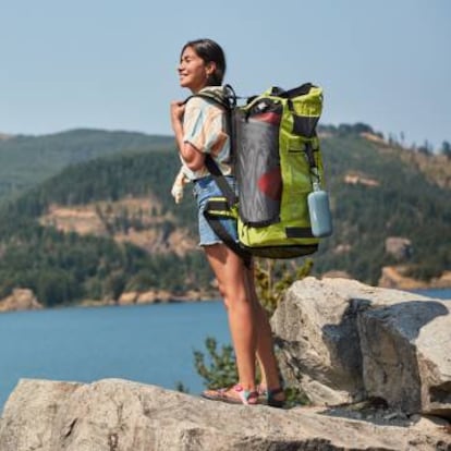 Una excursionista carga en su mochila con los altavoces 'outdoor' Soundlink Flex de Bose.