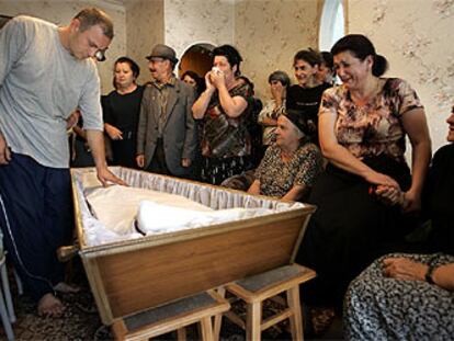 Eduard Bitsieyev, acompañado de otros familiares, vela a su hijo Zaur, de ocho años, muerto en la escuela de Beslán.