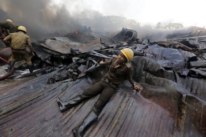 Un bombero agotado tras participar en las labores de extinción de un incendio en una fábrica de pintura en Howrah, cerca de Carlcuta. Un total de 25 efectivos han tardado seis horas en extinguir el incendio en el que no ha habido que lamentar ningún daño personal.