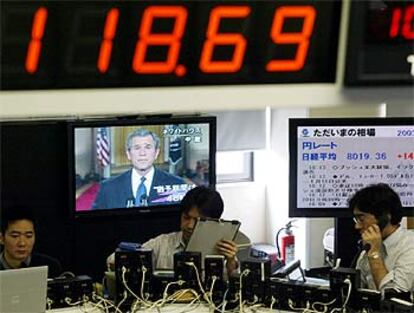 Operadores de la Bolsa de Tokio escuchan el ultimátum de Bush a Husein.