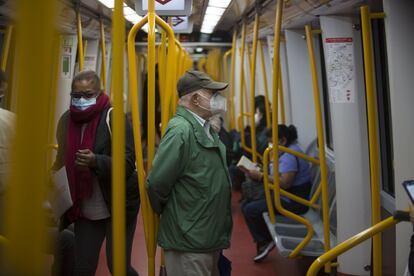Varias personas viajan en la línea 6 del Metro de Madrid, este lunes.