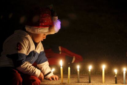 Un niño enciende unas velas en el parque Simón Bolívar, de Bogotá, para marcar el inicio de las fiestas de Navidad.