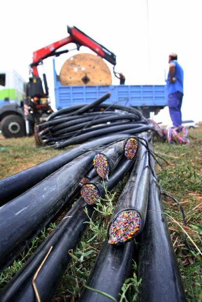 Unos operarios reparan y recogen los restos de la línea telefónica que unos desconocidos intentaron robar en Cistella.