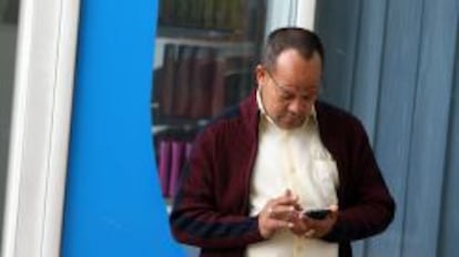 Un hombre consulta su teléfono movil.