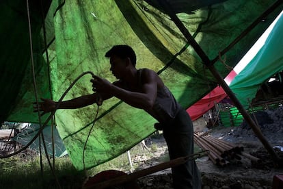 Un trabajador birmano recoge una cuerda en un yacimiento de petróleo el 11 de agosto de 2015, en Minhla. Los agricultores empiezan trabajando para otros hombres que ya tienen maquinaria propia para realizar extracciones. Cuando ahorran, perforan sus propios pozos en busca del oro negro.