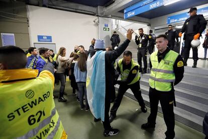 Personal de seguridad registra a los aficionados que van entrando al estadio Santiago Bernabéu.