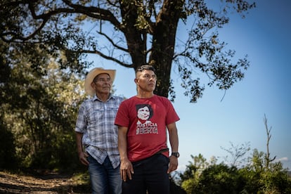 Felipe Gómez y Adolfo Gómez posan para un retrato frente a El Roble, sitio en el cuál acamparon pobladores de la comunidad Río Blanco para defender el río Gualcarque, en Intibucá, el 11 de febrero de 2026.  Berta Cáceres, lideresa del pueblo lenca y coordinadora del Consejo Cívico de Organizaciones Populares e Indígenas de Honduras (COPINH), dedicó su vida a la defensa del río Gualcarque y a la oposición del proyecto hidroeléctrico Agua Zarca, impulsado por la empresa DESA. Su lucha le valió amenazas constantes, campañas de criminalización y medidas cautelares internacionales que, sin embargo, no impidieron su asesinato.  El 2 de marzo de 2016  dos sicarios le quitaron la vida en su hogar, diez años después aún se exige verdad y justicia para su caso.