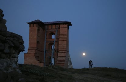 Una pareja camina bajo la luz de la 'superluna' junto a los restos de un fuerte medieval en Novogrudok (Bielorrusia).