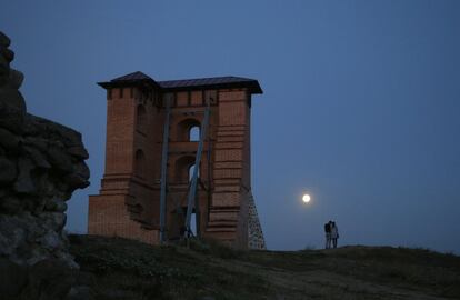 Una pareja camina bajo la luz de la 'superluna' junto a los restos de un fuerte medieval en Novogrudok (Bielorrusia).