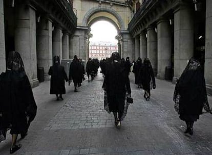 Mujeres con mantilla entran en procesión a la plaza Mayor.