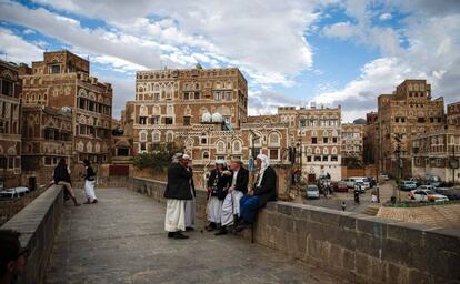 Un grupo de yemeníes se sientan y hablan en un puente de la ciudad vieja de Saná catalogada como bien cultural de la Unesco.