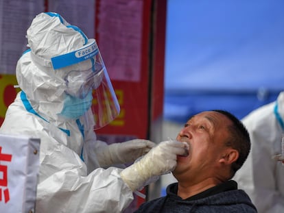 Um profissional sanitário faz exame de coronavírus em um morador da cidade de Shulan, no nordeste da China.